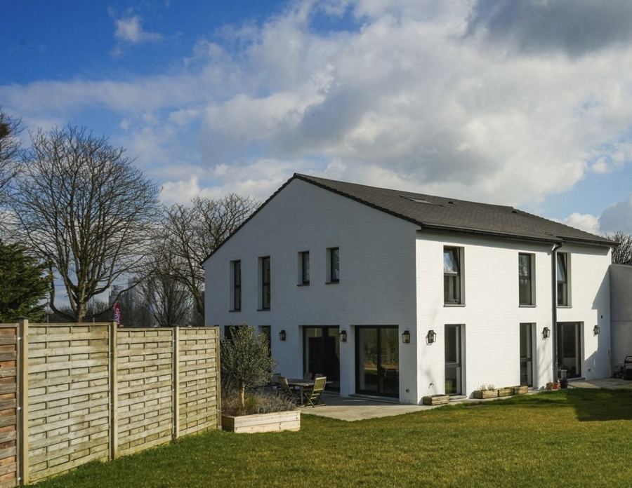Maison neuve à façade blanche et jardin